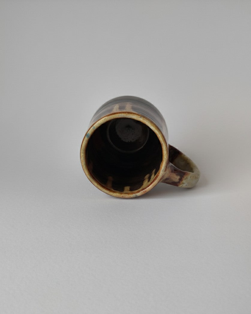 Ceramic mug with brown glaze on a white background