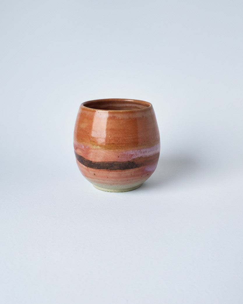 Ceramic cup with a striped design on a light gray background