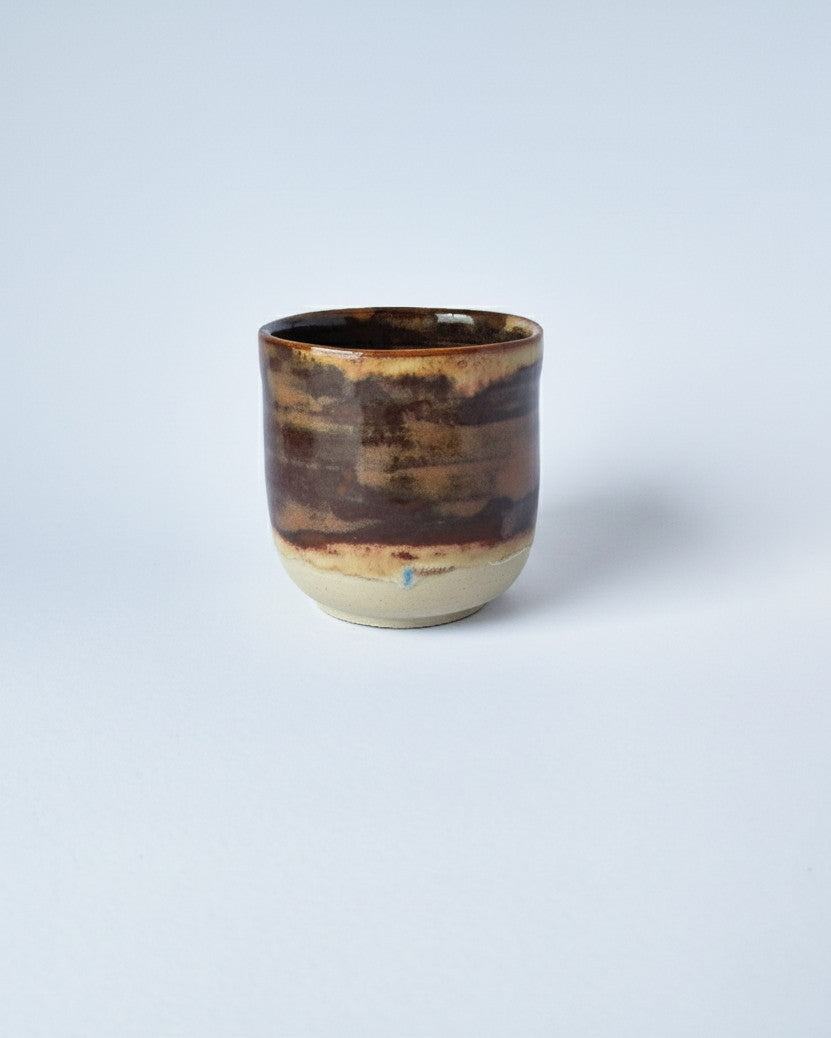 Stoneware mug with brown glaze on a white background